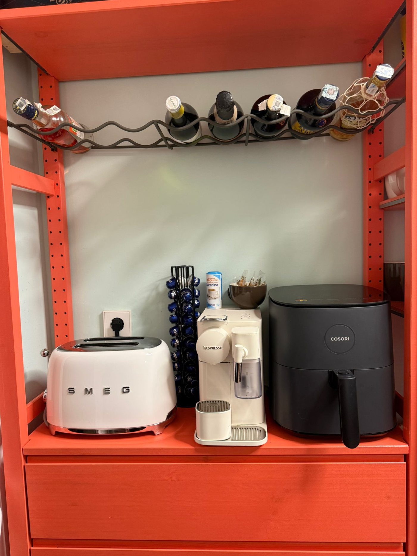 Rincón de desayuno con cafetera Nespresso, tostadora y freidora de aire sobre el mueble rojo